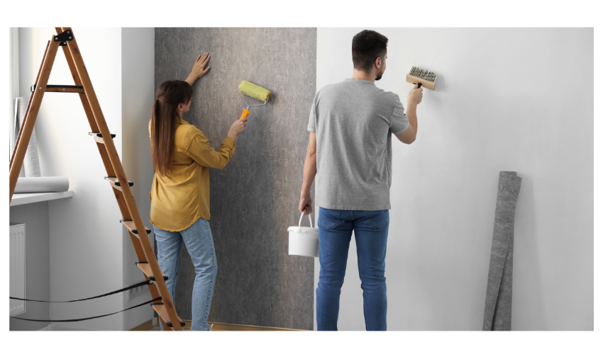 Two people carefully installing wallpaper on a residential wall
